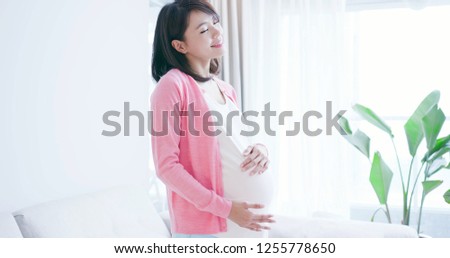 beauty pregnant woman smile and think something at home