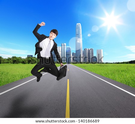 Excited Business man jump and run on the road with city background. concept for success business, asian man