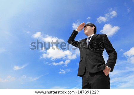 Successful handsome business man purposefully looking away with blue sky and city background, mode is a asian male