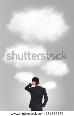 Back pose of a business person thinking with cloud and gray background, asian model