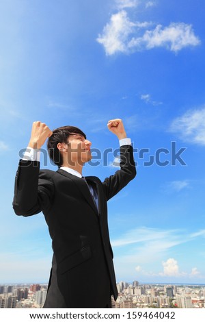 happy successful business man raised arms with sky in the background, asian people