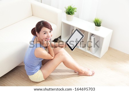 happy woman using tablet pc on sofa in the living room, empty computer screen is great for your design copy space, asian beauty