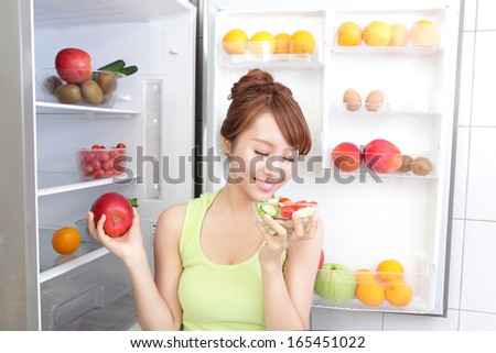 Healthy Eating Concept .Diet. Beautiful Young Woman near the Refrigerator with healthy food. Fruits and Vegetables, asian model
