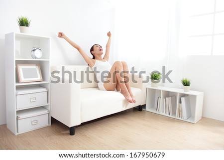 Young beauty with perfect  figure in white underwear cheering  on sofa