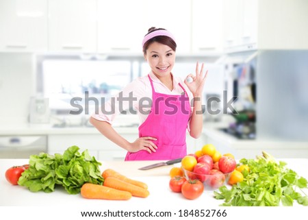 Happy smiling woman in kitchen with fresh produce vegetables preparing for a healthy meal, asian