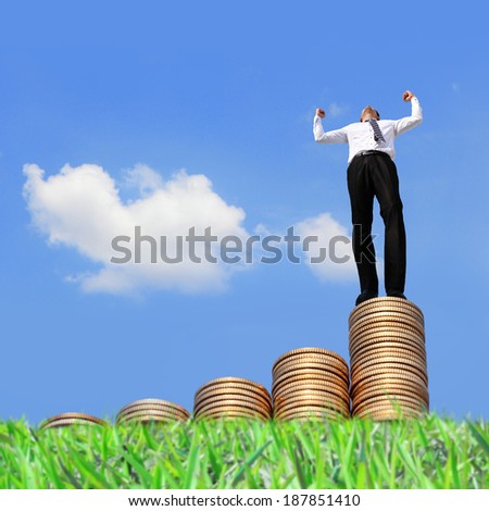 Successful business man standing on growth money stairs coin with sky