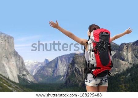 Travel in Yosemite Park, happy woman with backpack raised arm hands and looking to sky, California, USA