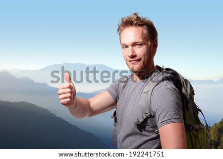 happy man mountain hiker with backpack and show thumb up on the top of mountains. caucasian