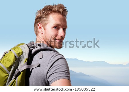 Successful man mountain hiker with backpack on the top of mountains. caucasian