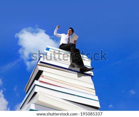 Knowledge is power - Happy business man using tablet pc computer and sitting on a stack Of Books