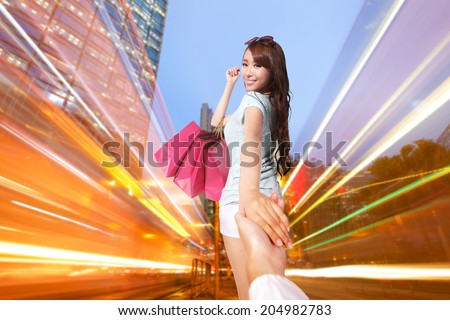 Happy Shopping in hong kong - beautiful young woman holding colored shopping bags at night, asian