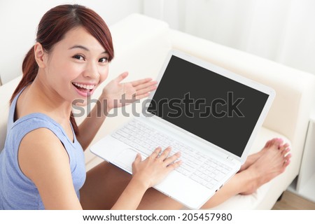 woman using laptop on sofa in the living room, empty computer screen is great for your copy space design, asian beauty