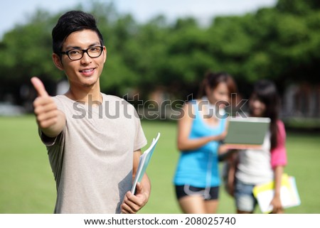 Happy College students smile to you on campus lawn, asian