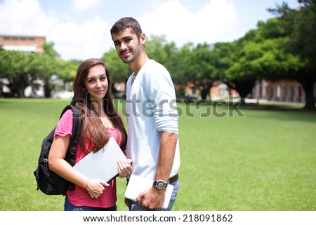 Happy College students smile to you on campus lawn, caucasian