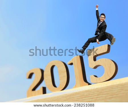 Happy new year for 2015 - success business man jump in the air cheering and celebrating on wood number