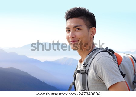 Successful man mountain hiker with backpack on the top of mountains. asian