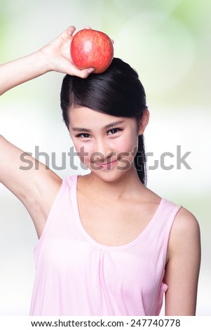 Beautiful young woman hold red apple with charming smile. Isolated over nature green background, asian beauty