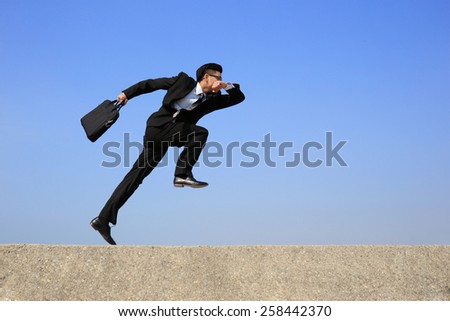 business man jump and run with blue sky background, full length, asian male, slight motion blur