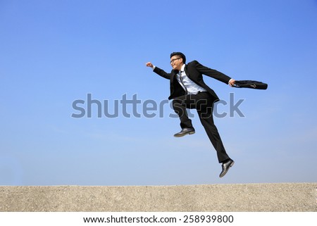 business man jump and run with blue sky background, full length, asian male