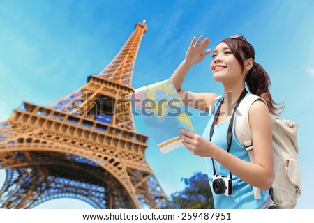 Happy travel woman in Paris with Eiffel Tower and she look map, asian beauty