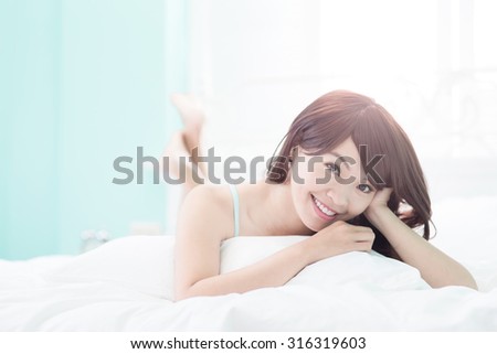 Health woman Smile to you and she lying on the bed in the morning , asian girl