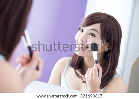 Close up of Smile woman with makeup brushes near face and look mirror. asian beauty