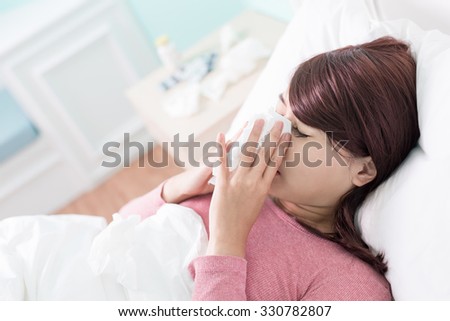 Sick Woman sneezing into Tissue. Flu and Woman Caught Cold.
