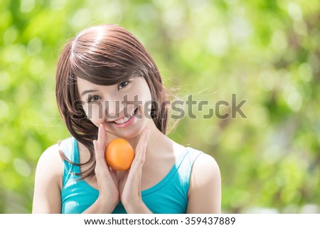 young health woman with orange. nature green background, asian beauty