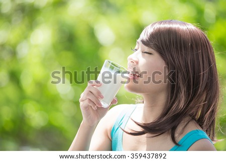 Beautiful Young Woman drinking milk with nature green background, healthy lifestyle concept, asian beauty