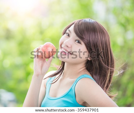 Beautiful young woman hold red apple with health teeth. nature green background, asian beauty