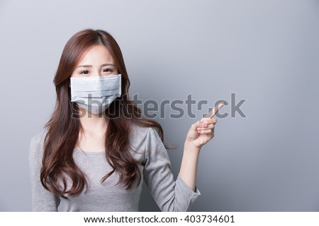 A Woman wears a mask and show something, illness, asian beauty,gray background