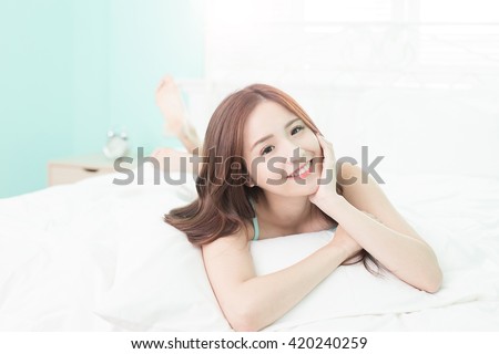 Health woman Smile to you and she lying on the bed in the morning , asian girl