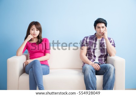young couple feel bad and look somewhere sit on sofa at home