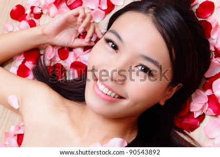 Asian beauty Girl smiling close-up with rose background, Beautiful young woman touching her face looking to the camera