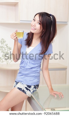 Happy Young Girl relax drink tea with home background, model is a asian beauty