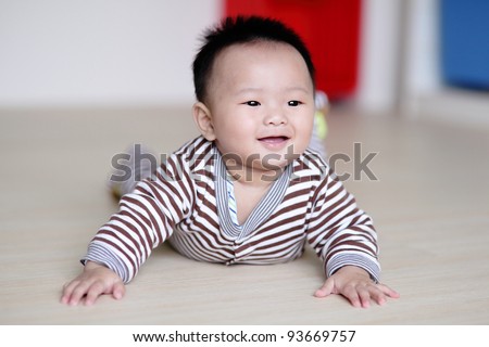 Cute Baby crawling on living room floor with home background, baby is a cute asian infant