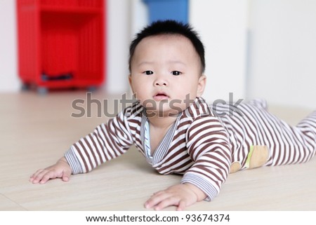 Cute Baby crawling on living room floor with home background, baby is a cute asian infant