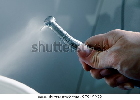 Dentist doctor hand holding dentist tools in Dentist Clinic  (blue tone)