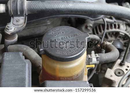 Power steering fluid cap with warning label