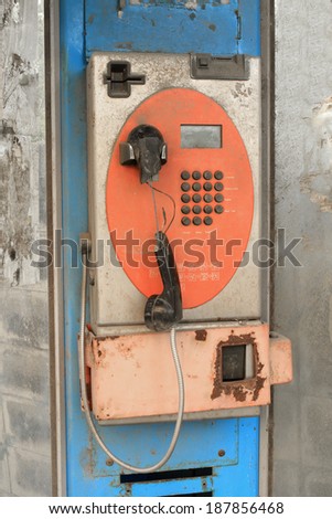 Abandoned public telephone, damaged and dirty