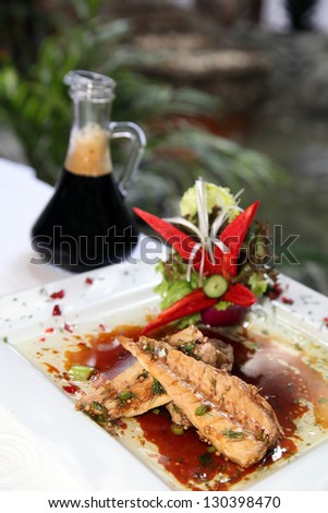 Bonito fish with sauce bottle on the restaurant table.