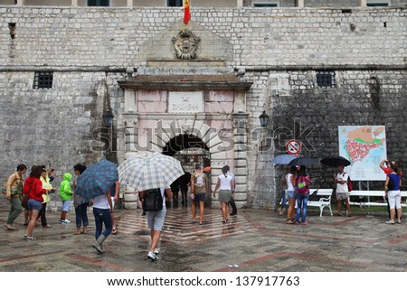 KOTOR, MONTENEGRO - SEPTEMBER 6: People walking in Kotor Castle entrance at rain on September 6, 2012 in Kotor, Montenegro. Kotor is part of the UNESCO World Heritage Site.