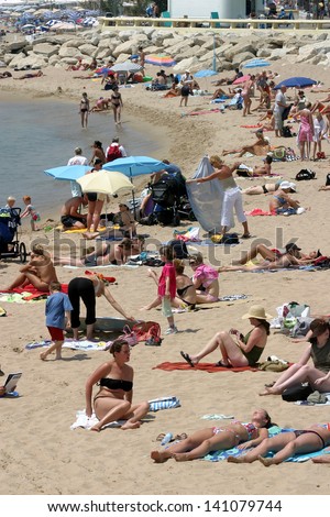 CANNES, FRANCE - JULY 24: Sunbathing people at Cannes Beach on July 24, 2006 in Cannes, France. Cannes beachfront, considered between 5 best urban beach of the Europe.
