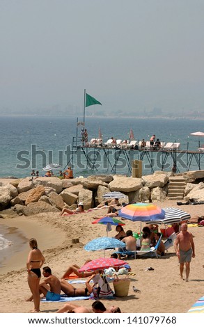 CANNES, FRANCE - JULY 24: Sunbathing people at Cannes Beach on July 24, 2006 in Cannes, France. Cannes beachfront, considered between 5 best urban beach of the Europe.