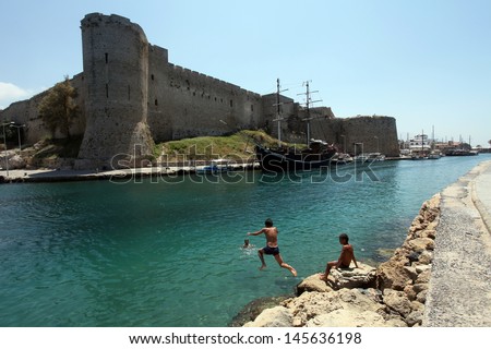 KYRENIA, NORTH CYPRUS - JUNE 17: Children swimming at medieval castle Kyrenia (Girne) on June 17, 2011 in Kyrenia, North Cyprus. Kyrenia harbor is currently a tourist resort.