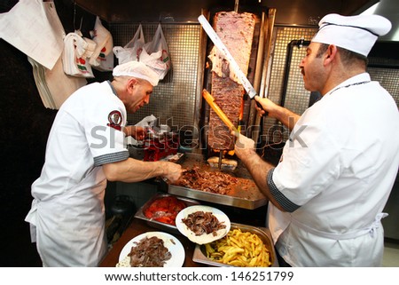 ISTANBUL, TURKEY - JUNE 29: Chefs cutting traditional Turkish food Doner Kebab in the restaurant on June 29, 2011 in Istanbul, Turkey.