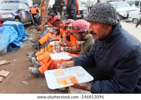 VAN, TURKEY - OCTOBER 25: Earthquake victim man and rescue team eating lunch on October 25, 2011 in Van, Turkey. It is 604 killed and 4152 injured in Van-Ercis Earthquake.