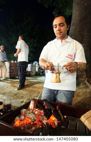 ISTANBUL, TURKEY - AUGUST 8: A man make Turkish coffee in Feshane at Ramadan night on August 8, 2011 in Turkey. Feshane is an entertainment center of Istanbul in Ramadan.
