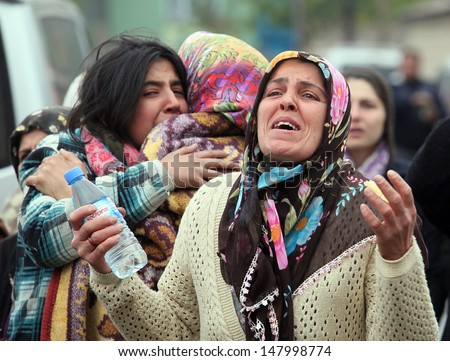 VAN, TURKEY - OCTOBER 25: Turkish women crying and praying in front of his house for own family on October 25, 2011 in Van, Turkey. It is 604 killed and 4152 injured in Van Earthquake.