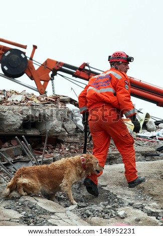 VAN, TURKEY - OCTOBER 25: Rescuer and rescue dog is searching for the wounded under the debris aftter the earthquake on October 25, 2011 in Van, Turkey. 604 killed and 4152 injured in Van Earthquake.